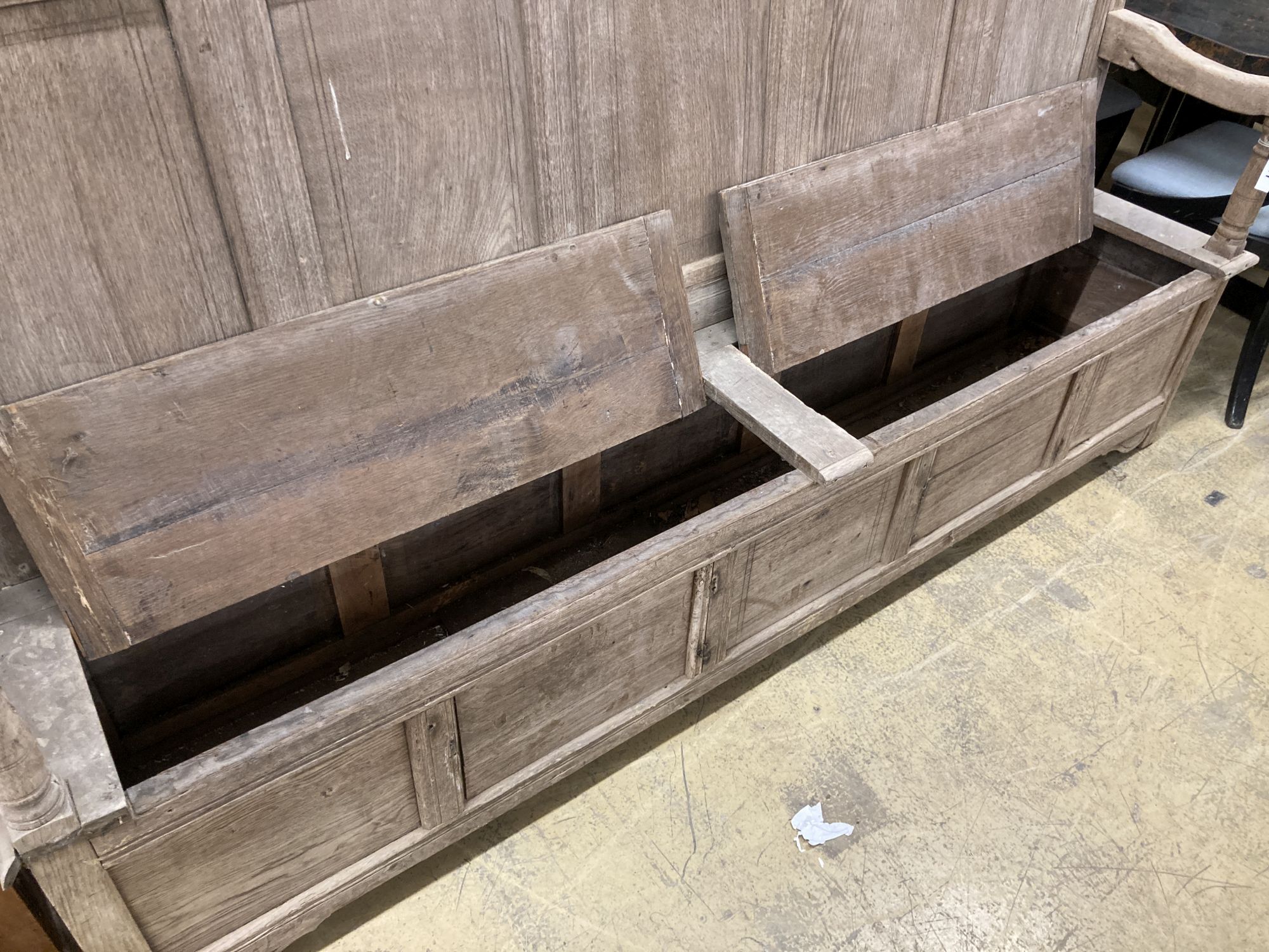 An 18th century bleached oak panelled box seat settle, length 206cm, depth 41cm, height 145cm